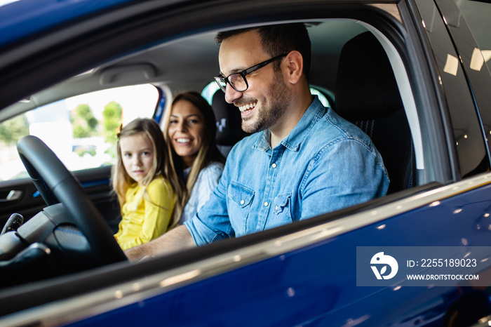 Happy family buying a new car at the car showroom.