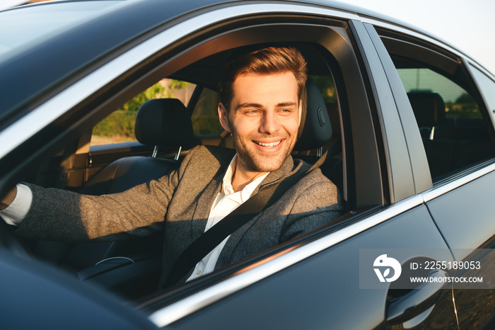 Front view of smiling bussinesman in suit driving