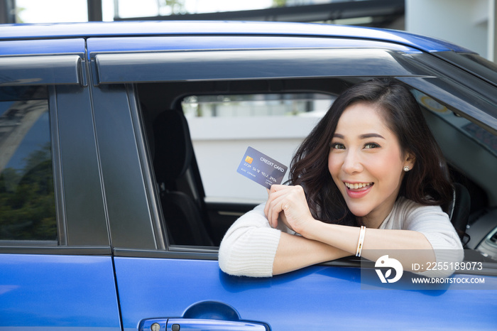 Happy young Asian woman holding payment card or credit card and used to pay for gasoline, diesel, and other fuels at gas stations, Driver with fleet cards for refueling car