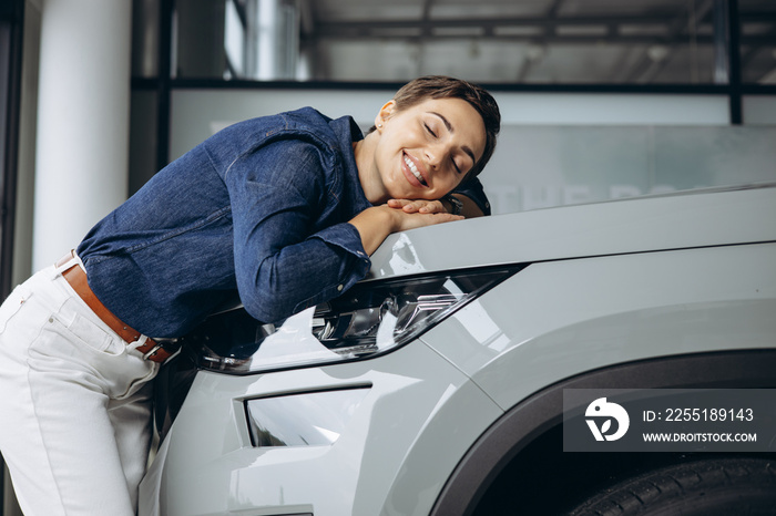 Woman hugging a new car in a car showroom