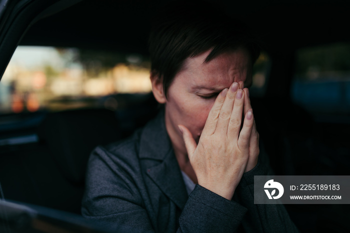 Anxious businesswoman sitting inside of the car