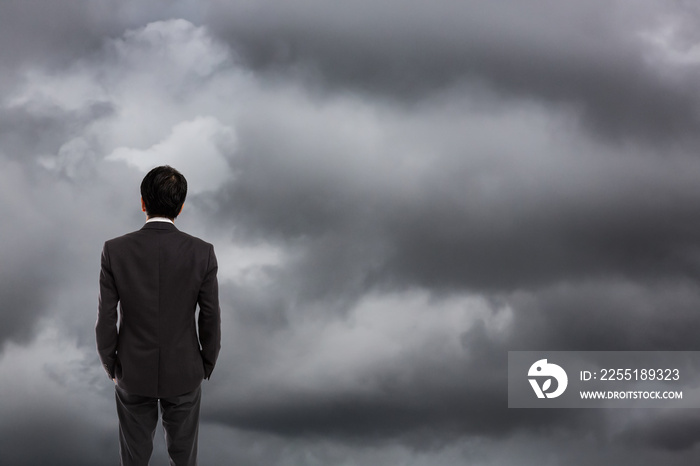 Businessman standing wtih storm cloudy background, Business crisis challenge concept
