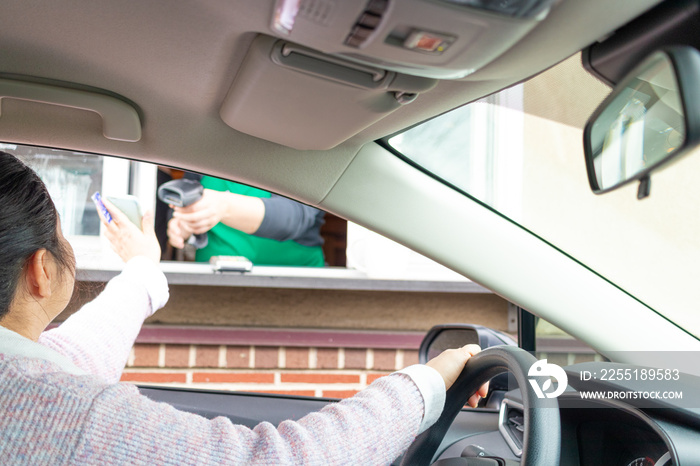 Woman pays for service through Drive thru