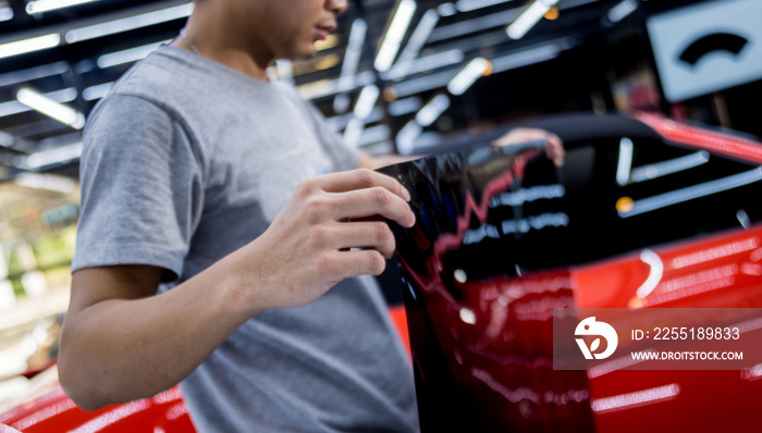 Applying tinting foil on a car window in a auto service