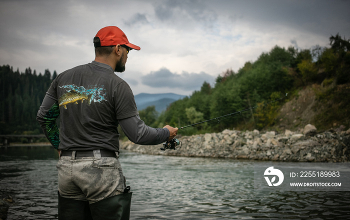 Fishing background. Fisherman catching trout on a river.