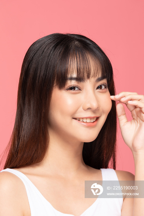 Beautiful Asian woman touching soft cheek smile with clean and fresh skin Happiness and cheerful with positive emotional,isolated on pink background,Beauty Cosmetics and spa Treatment Concept