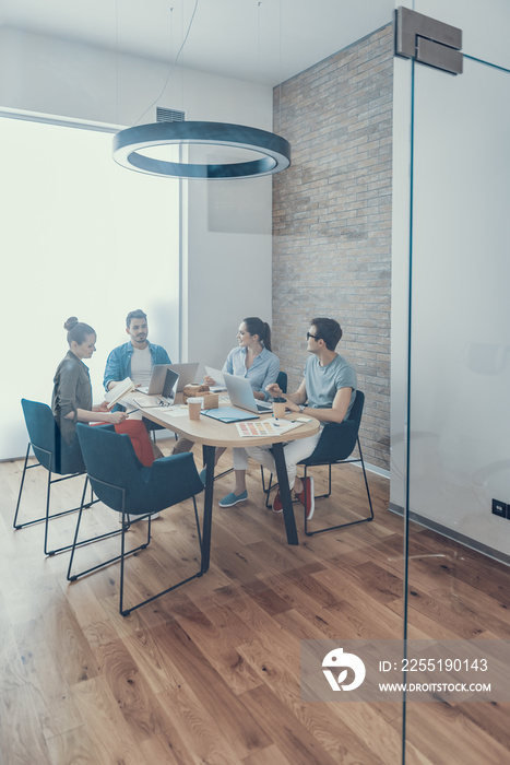 Smiling colleagues are talking in meeting room