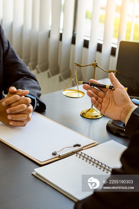 Businessmen and lawyers discussing contract Businessman and lawyer discussing contract documents sitting at a table legal concept Consultants with hammers and scales placed next to each other with a v