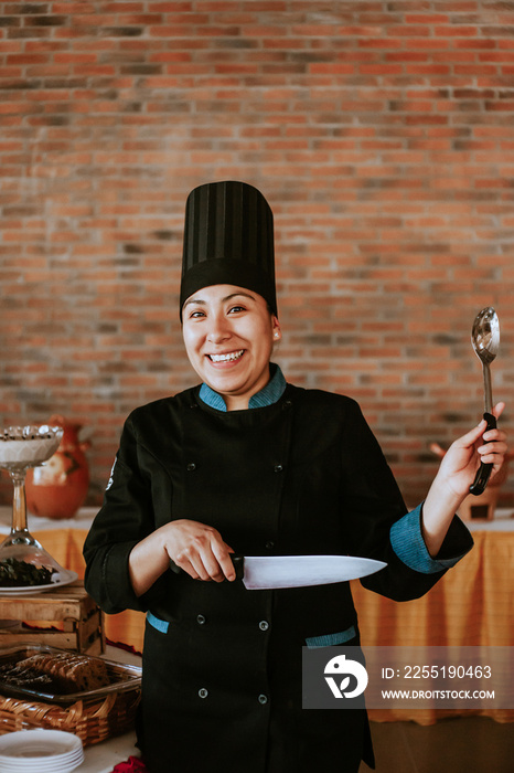 hispanic woman chef holding a spoon in mexican restaurant