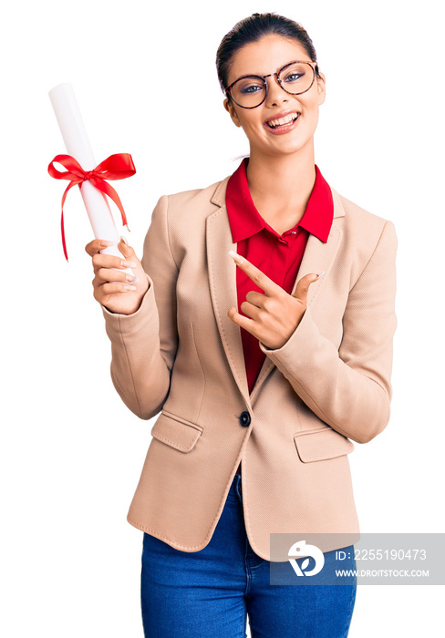Young beautiful woman wearing glasses holding graduate degree diploma smiling happy pointing with hand and finger
