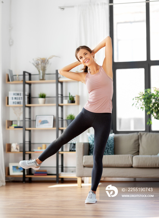 sport, fitness and healthy lifestyle concept - smiling young woman exercising at home