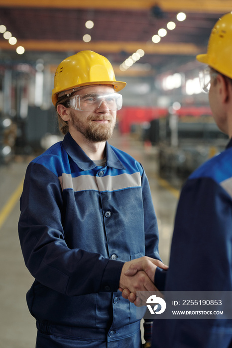 Bearded employee shaking hand of coworker