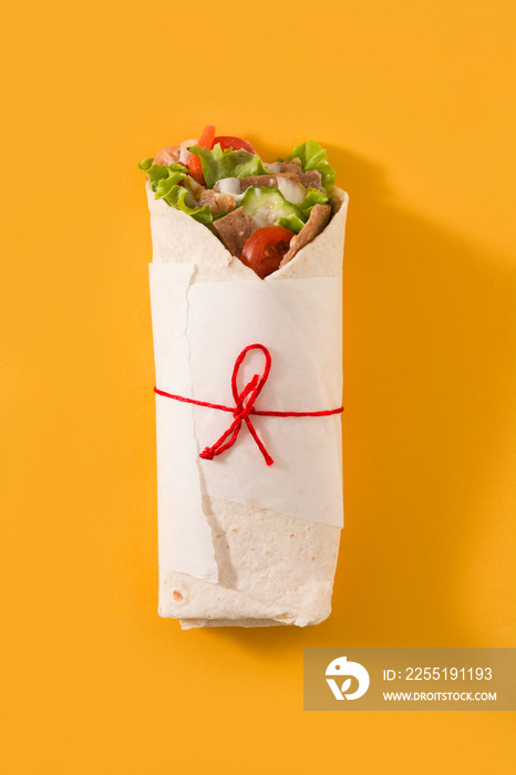 Doner kebab or shawarma sandwich isolated on yellow background	. Top view