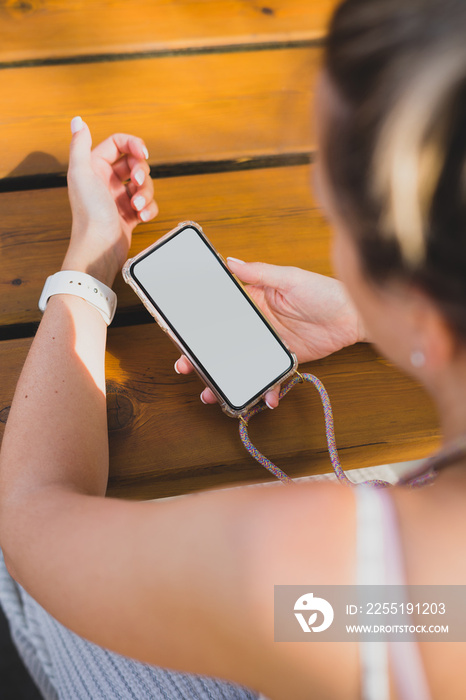 Mockup of a woman using her smartphone on a wood table