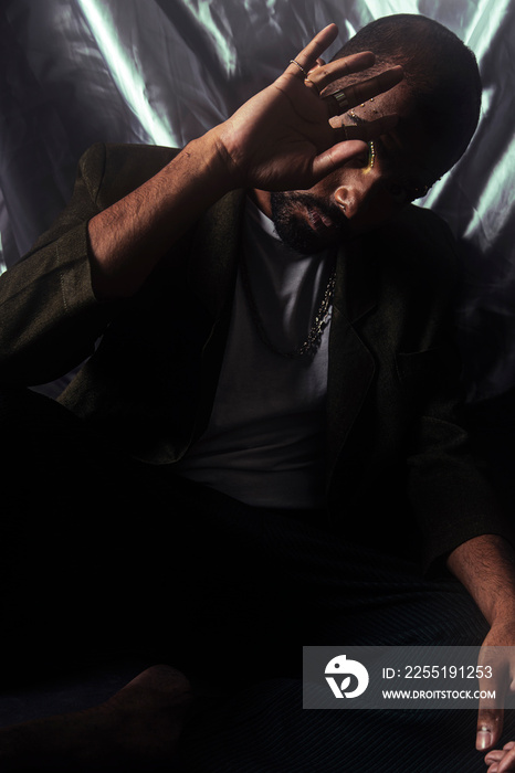 Two Malaysian Indian men in a studio setting with cloth flying in the background, posing against a black bacground