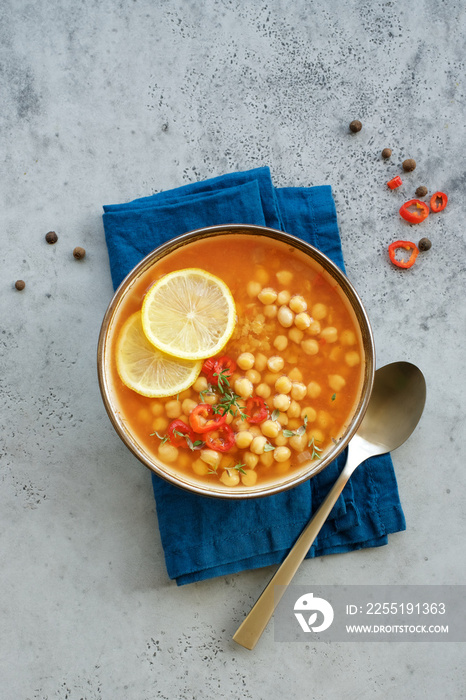 Chickpea lentil soup in bowl on gray background. Harira Moroccan soup. Comfortable food in the cold season