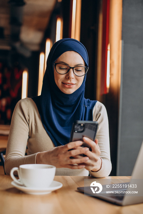 Muslim business woman working on computer in a cafe