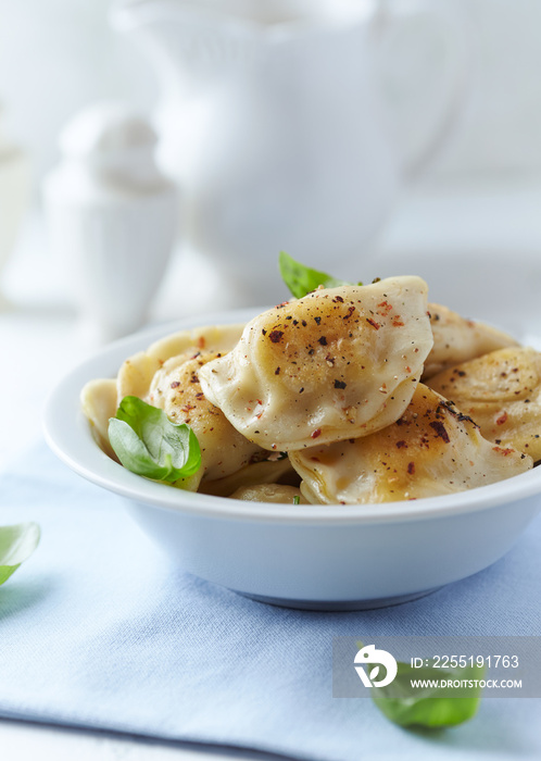 Dumplings with potato and cottage cheese stuffing (pierogi). Traditional Polish Christmas Dinner. Bright background.