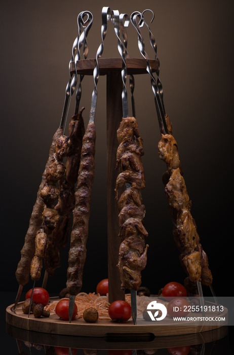 kebab on skewers in a vertical position on a dark background