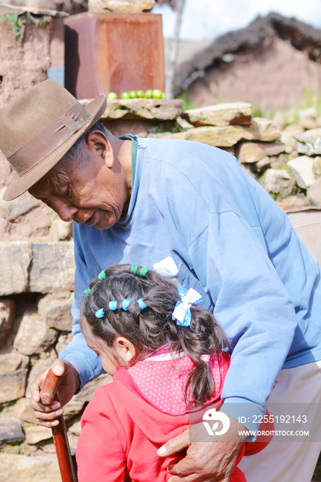 Native american grandfather hugging his grandchild outside.