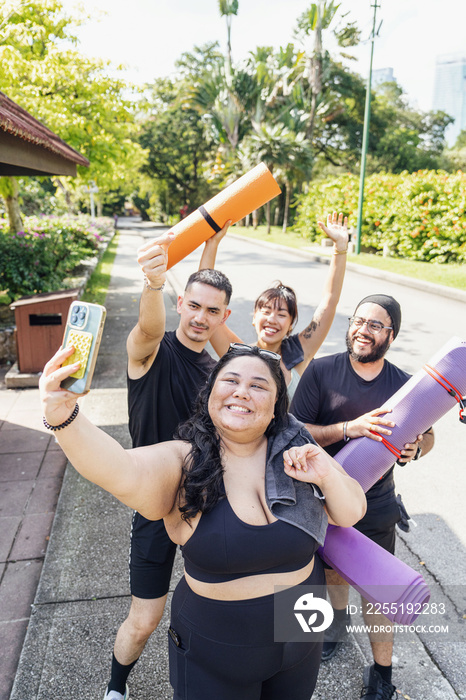 Group of friends taking a selfie together in the park after working out