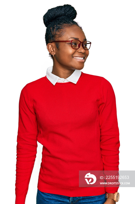 Young african american woman wearing casual clothes and glasses looking away to side with smile on face, natural expression. laughing confident.