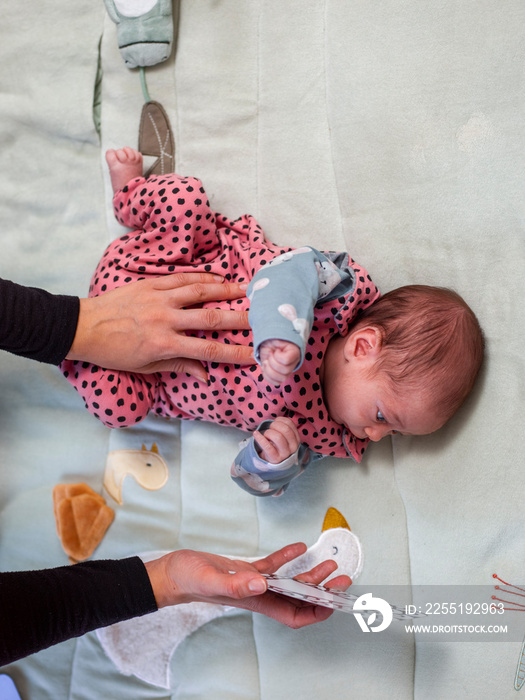 Mother showing picture to infant daughter