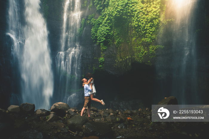 Amazing romantic view of happy couple near beautiful grand waterfall