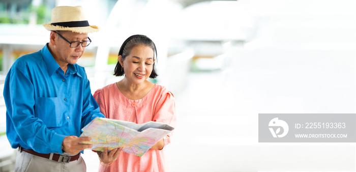 Travel and tourism concept. Happy Senior couple woman and man traveling together looking for destination with city map