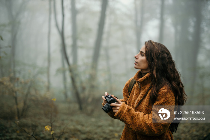 Gorgeous woman taking pictures outdoors with a digital camera. Copy space