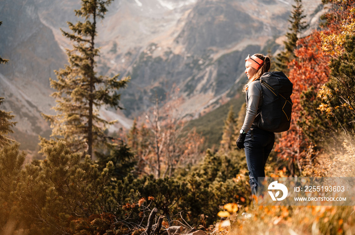 Young traveler hiking girl with backpacks. Hiking in mountains. Sunny landscape. Tourist traveler on background view mockup. High tatras , slovakia