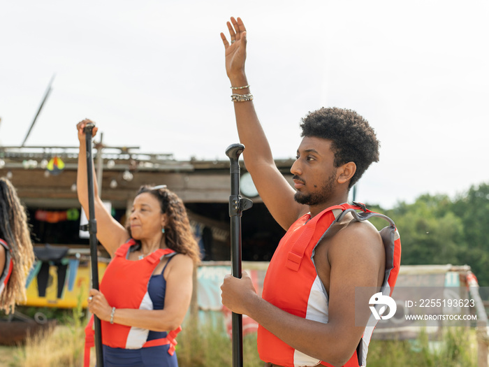 Man and woman warming up with oars before paddleboarding