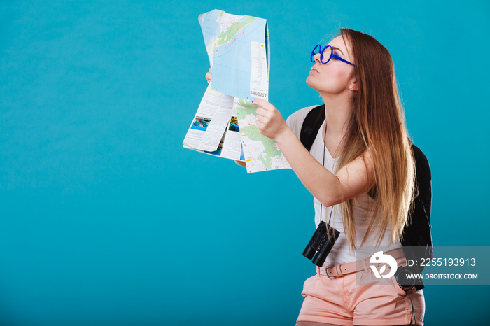 Tourist woman sunglasses read map on blue