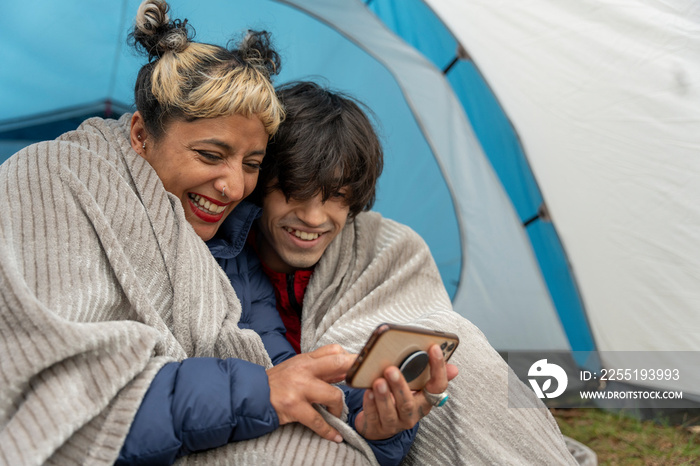 Mother and son using phone in tent