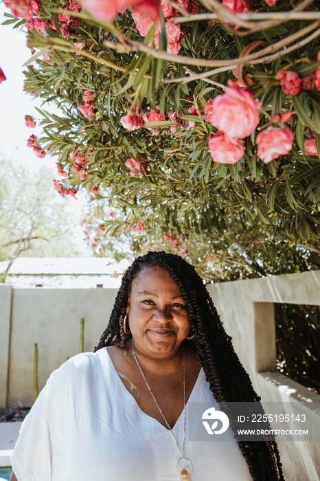 African American woman smiling under flowering tree