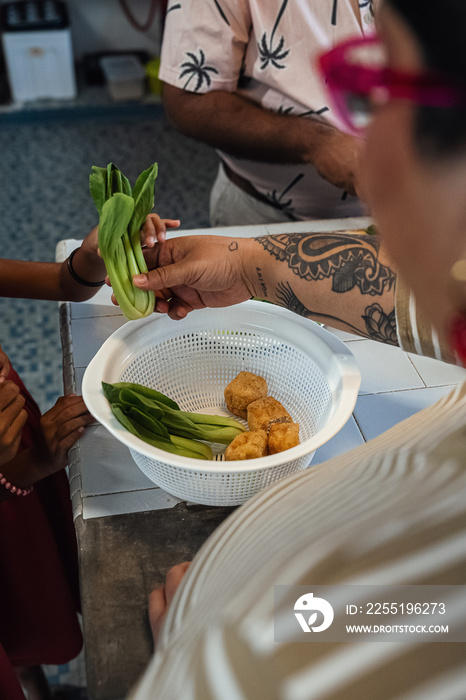 Kids helping their parent cook a healthy meal for the family dinner at home