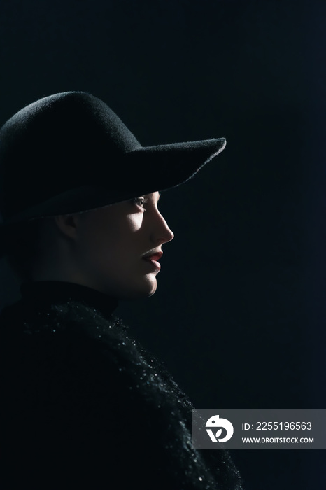 Vintage 1940s woman in black hat. Side view.