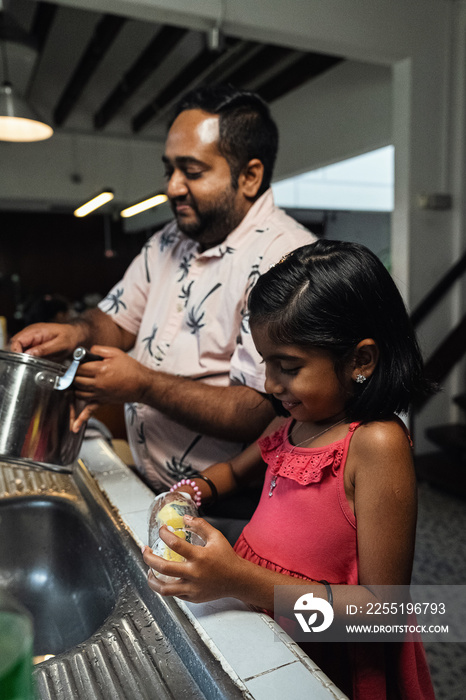 Children helping their parents wash up after dinner