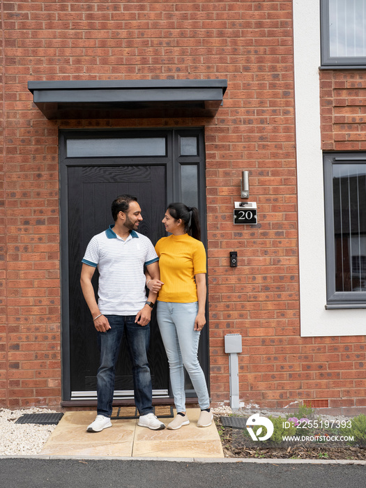 Smiling couple standing on front porch