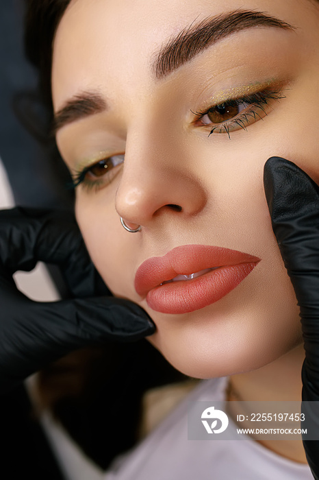 Beautiful lips of a girl with a permanent make-up of the lips close-up. Lip tattoo matte effect.