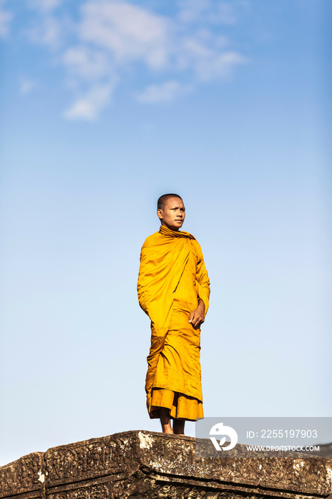 Young Buddhist monk standing outside temple in Angkor Wat, Siem Reap, Cambodia