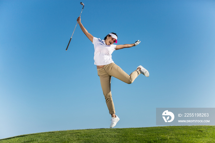 Cheerful woman jumping on golf course