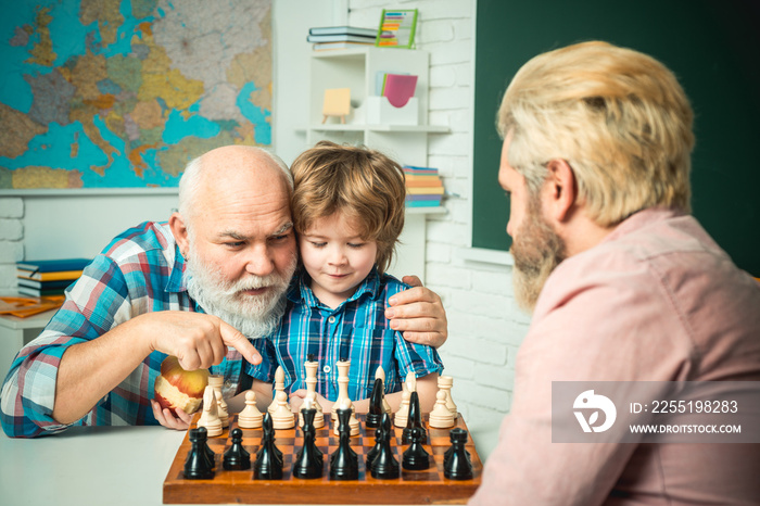 Portrait grandpa and grandson playing and learning. Family relationship between grandfather father and son. Grandpa teaching school boy playing chess.