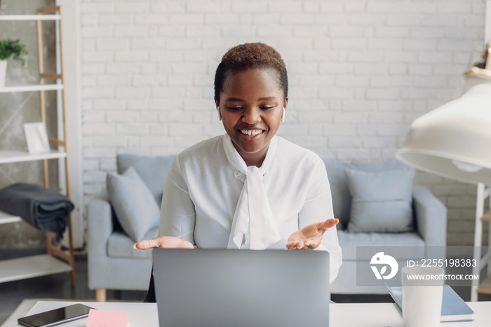 Happy beautiful african american woman freelancer, talking by video call having an online meeting with colleagues. Female having online web conference at home