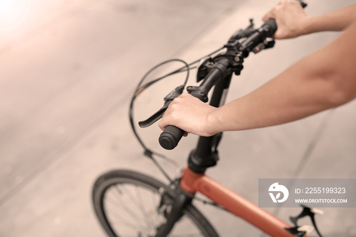 Woman riding a bicycle. Closeup on handlebar with female hand. Healthy lifestyle and sport concept