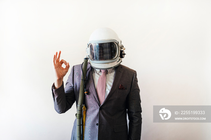 Businessman with astronaut helmet showing fingers in OK shape