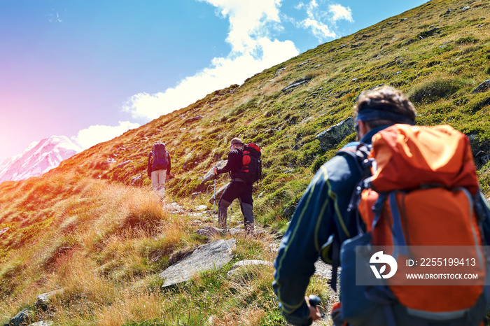 hikers with backpacks on the trail in the Apls mountains. Trek near Matterhorn mount