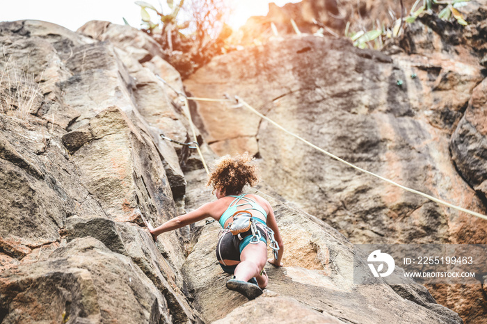 Young woman climbing a rock wall in a canyon - Strong climber training outdoor - Travel, female power and extreme dangerous sport concept - Focus on her head