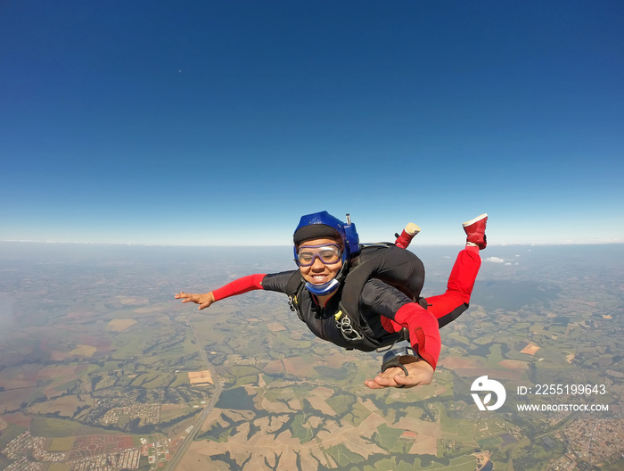 Smiling black woman jumping from parachute