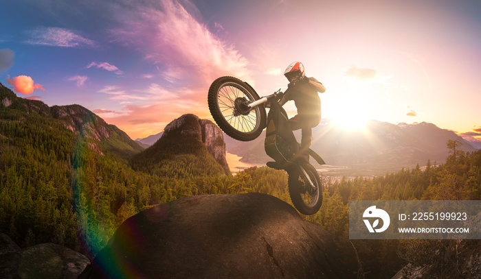 Extreme Adventure Man Motorcycle trials on top of a rock. Dramatic Mountain Sunset Composite. Landscape from British Columbia, Canada. Sunset Color Sky